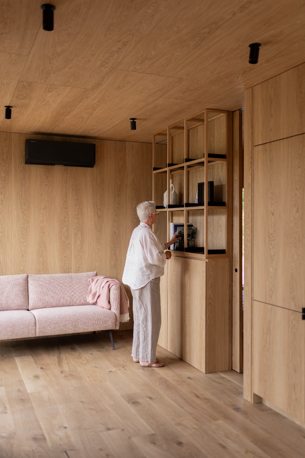 Woonkamer met bank en een gevulde boekenkast